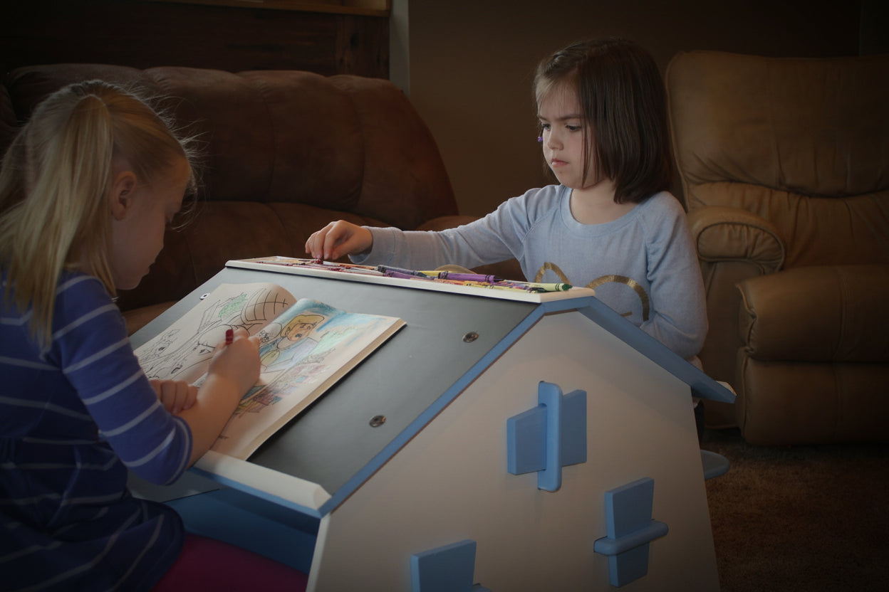 Two kids sitting at the double desk.